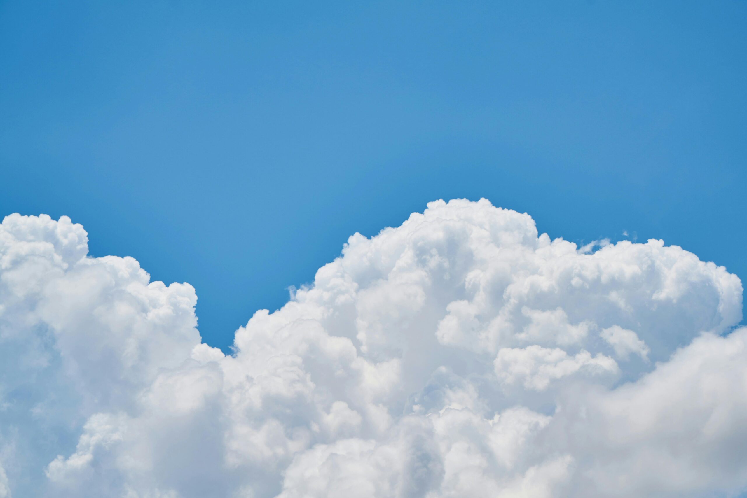 Vibrant image of fluffy white clouds against a clear blue sky, perfect for nature and weather themes.